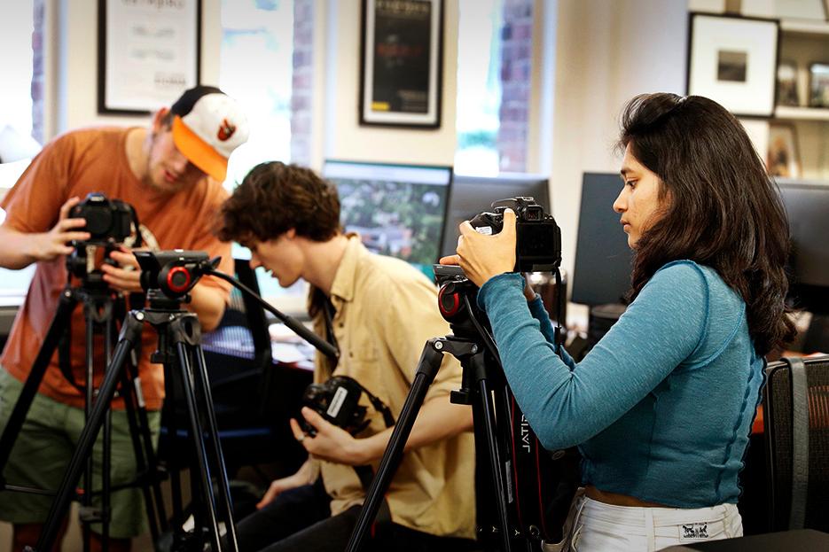 Three students work in the DOCLab with camera equipment during a documentary studies course in fall 2022. 